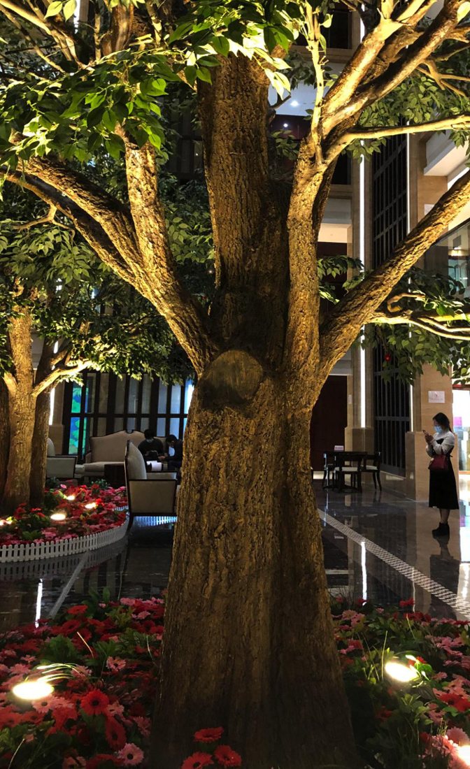 The finished tree lit from below in a hotel lobby garden