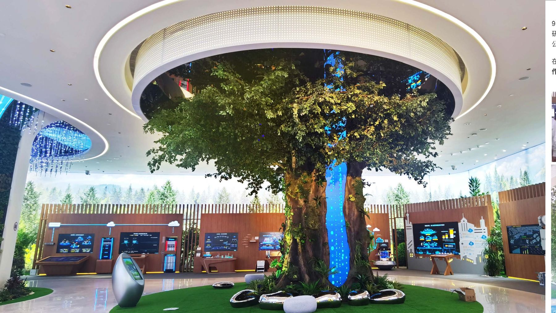 A large artificial tree under a circular lit ceiling in a corporate exhibition hall