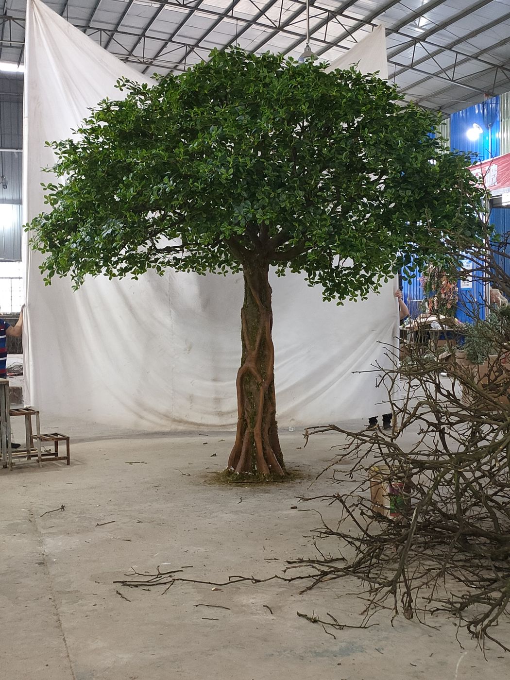 A finished artificial tree against a white backdrop in the workshop
